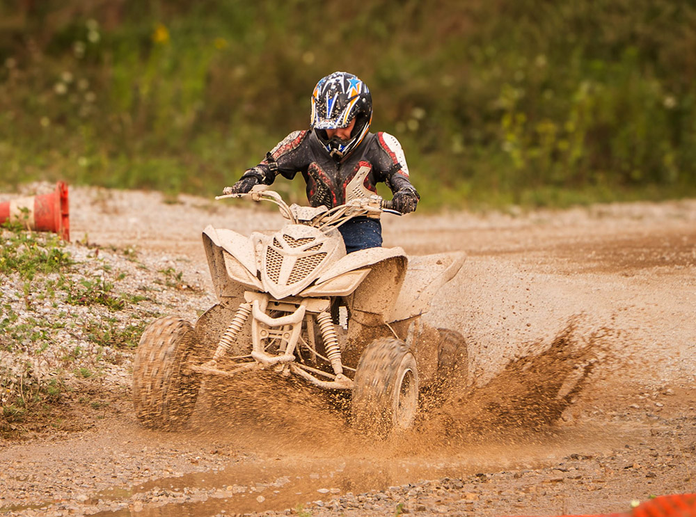Actionfoto von einem Quad im Schlamm bei Sandkiste XXL Aichberger